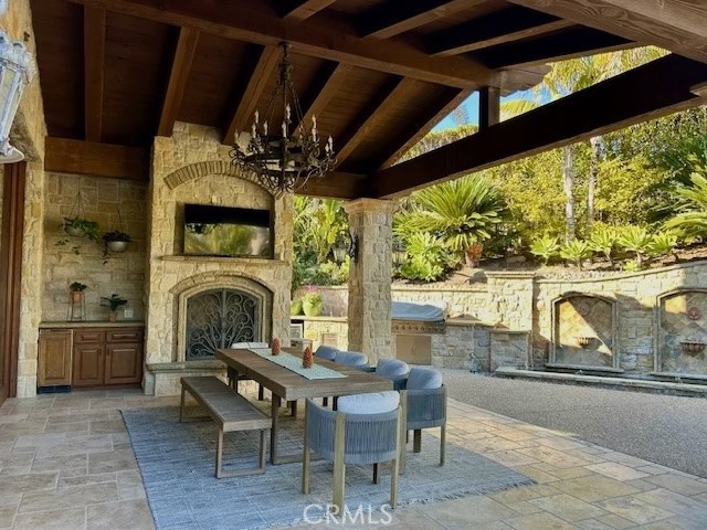 view of patio / terrace featuring a gazebo and an outdoor stone fireplace