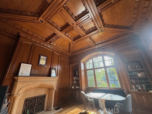 interior space featuring wooden ceiling, coffered ceiling, a premium fireplace, and wooden walls