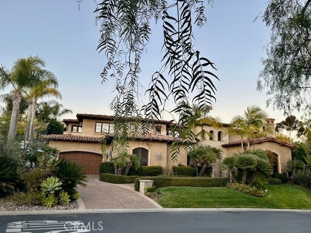 mediterranean / spanish house with a garage and a lawn