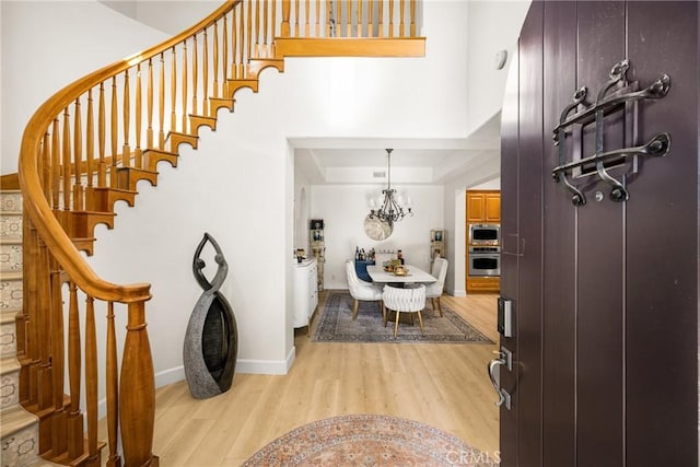 entrance foyer featuring light hardwood / wood-style flooring and a notable chandelier