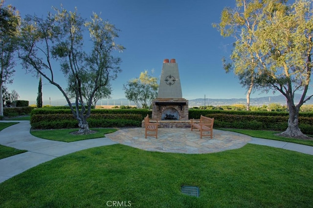 view of home's community featuring a mountain view, a patio, and a yard