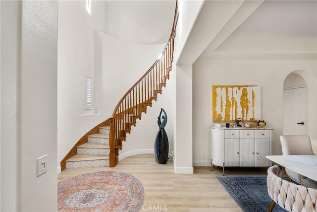 foyer entrance featuring a high ceiling and light hardwood / wood-style flooring