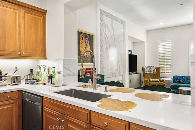 kitchen with light stone countertops, sink, black dishwasher, and kitchen peninsula