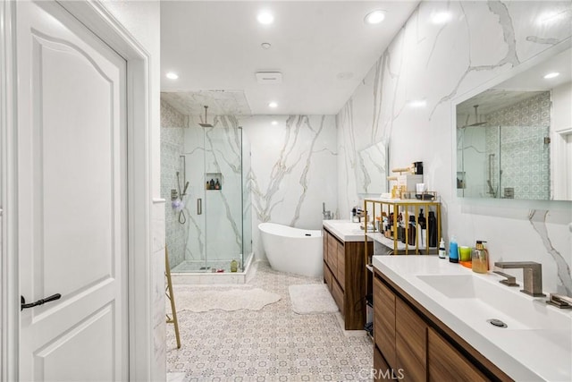 bathroom with shower with separate bathtub, tile walls, and vanity