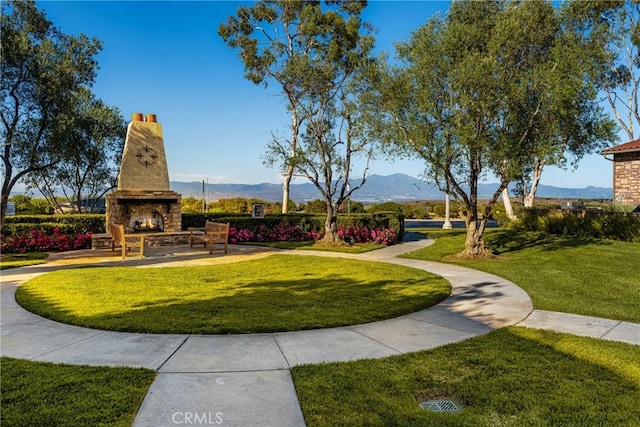 view of home's community with a mountain view and a yard