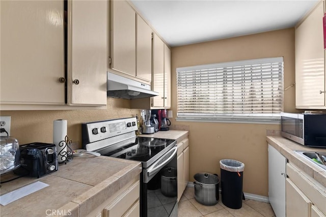 kitchen featuring tile counters, light tile patterned floors, and appliances with stainless steel finishes