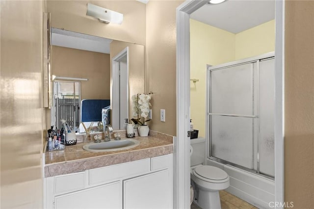 full bathroom featuring combined bath / shower with glass door, vanity, tile patterned flooring, and toilet