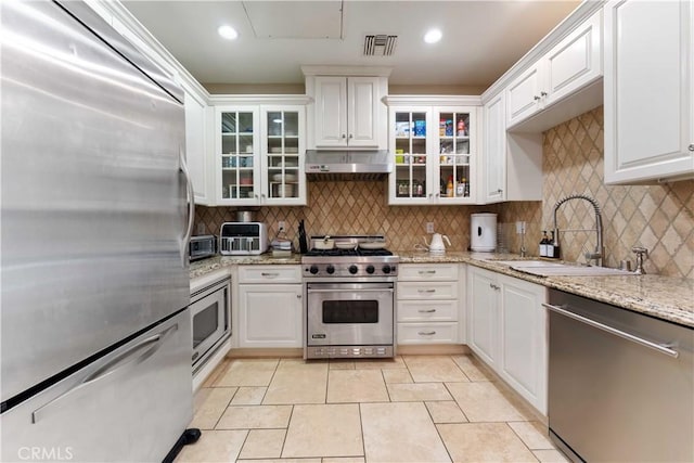 kitchen with light tile patterned floors, sink, white cabinets, and stainless steel appliances