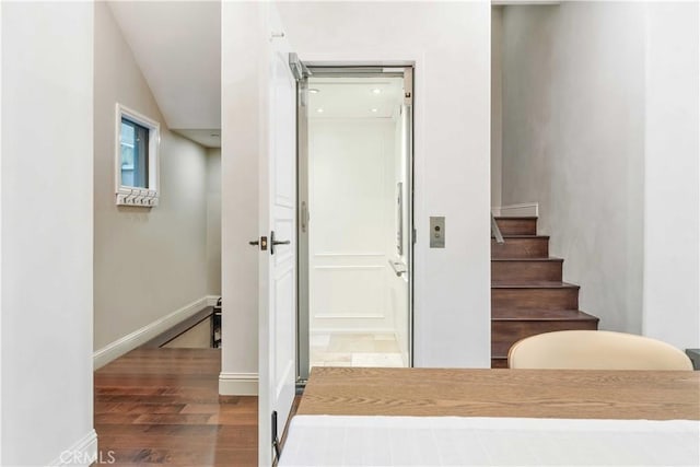 stairway with hardwood / wood-style flooring