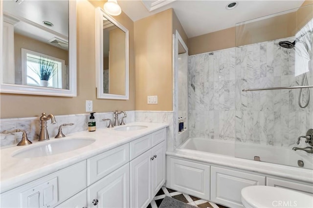 full bathroom featuring toilet, tiled shower / bath, and vanity