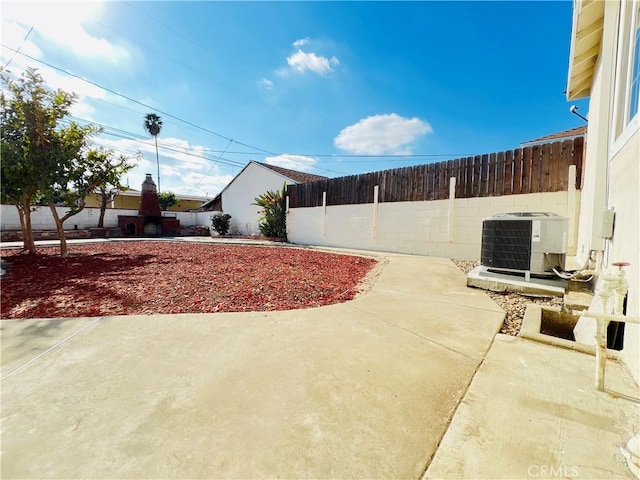 view of yard with central AC unit and a patio