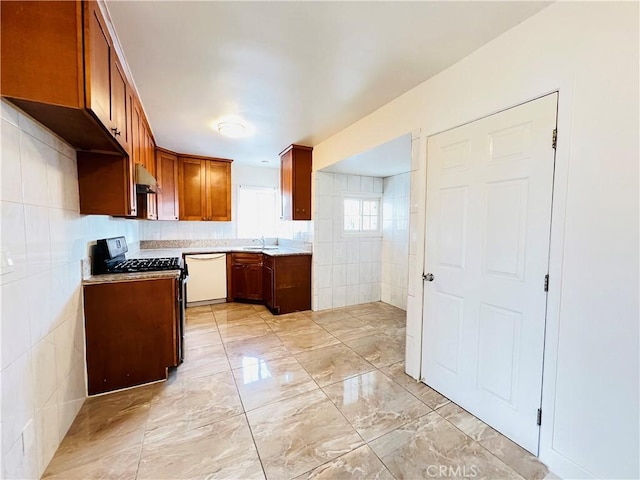 kitchen featuring gas range oven, tile walls, dishwasher, and sink