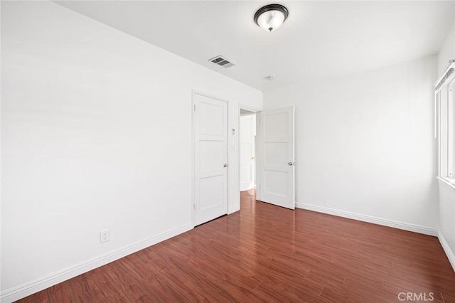 unfurnished bedroom featuring dark hardwood / wood-style flooring