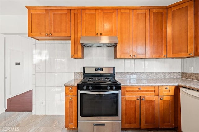 kitchen featuring light stone counters, decorative backsplash, white dishwasher, and stainless steel gas stove