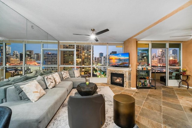 living room with floor to ceiling windows, a tile fireplace, and ceiling fan