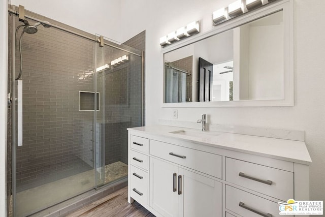 bathroom with vanity, a shower with door, and hardwood / wood-style floors