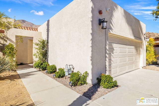 view of property exterior featuring a garage and a mountain view