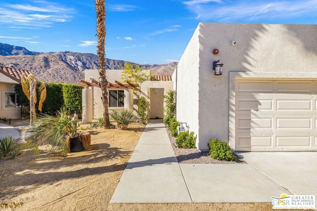 pueblo-style house featuring a garage and a mountain view