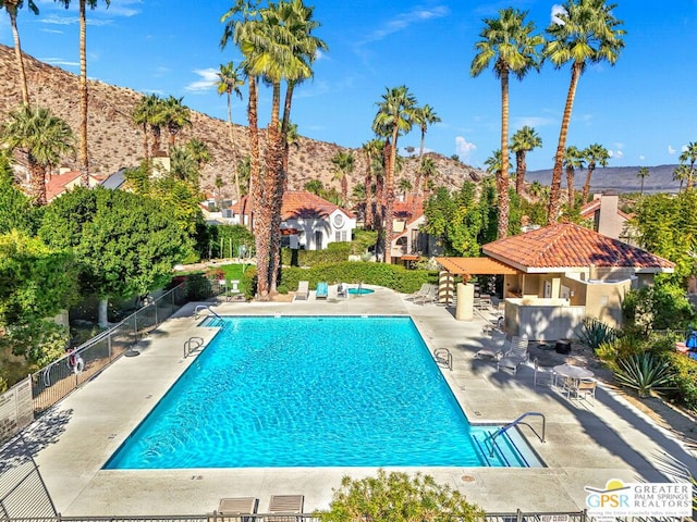 view of pool with a mountain view and a patio