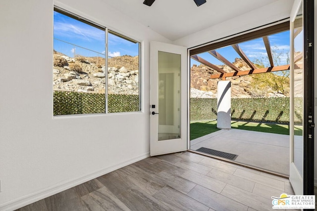 doorway with ceiling fan, a healthy amount of sunlight, and light wood-type flooring