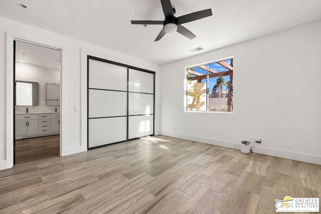 unfurnished bedroom featuring ceiling fan and ensuite bathroom