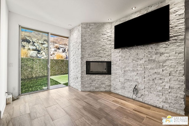 unfurnished living room with a stone fireplace