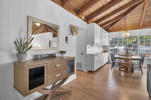 kitchen featuring white cabinetry, wood ceiling, decorative light fixtures, lofted ceiling with beams, and light hardwood / wood-style flooring