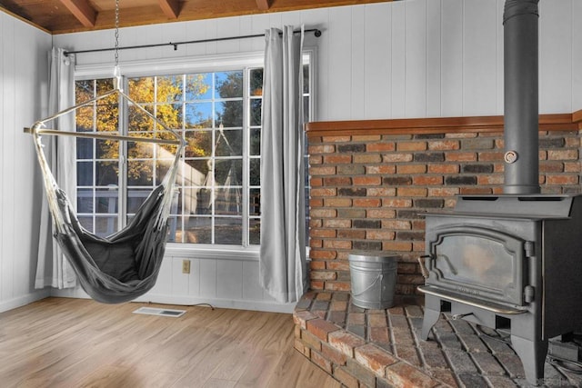 interior details with hardwood / wood-style flooring and a wood stove