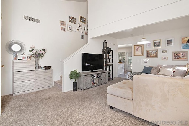 living room featuring a towering ceiling and carpet floors