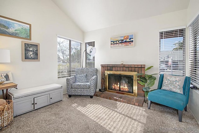 sitting room with a brick fireplace, high vaulted ceiling, and carpet floors