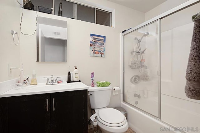 full bathroom featuring combined bath / shower with glass door, vanity, and toilet