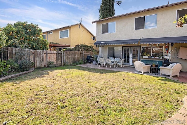 rear view of house featuring a patio area, a yard, and an outdoor living space