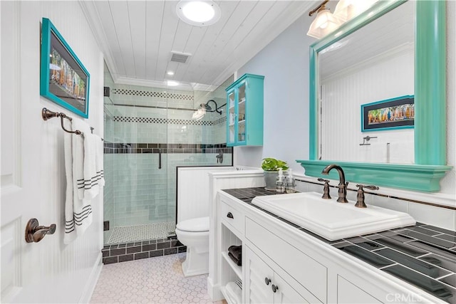 bathroom with tile patterned flooring, vanity, toilet, a shower with shower door, and crown molding