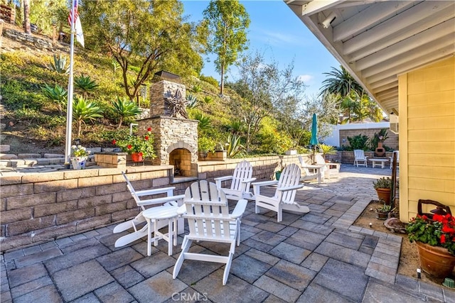 view of patio / terrace featuring an outdoor stone fireplace