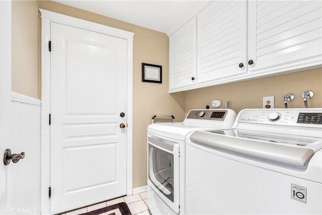 washroom featuring cabinets, light tile patterned floors, and washer and dryer