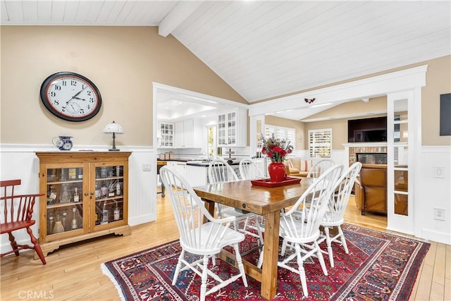 dining area with lofted ceiling with beams, light wood-type flooring, and wooden ceiling