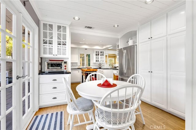 dining area with light wood-type flooring, ornamental molding, wood ceiling, and french doors