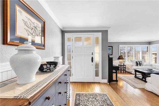 entryway with light hardwood / wood-style floors and ornamental molding