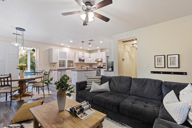 living room with ceiling fan and wood-type flooring