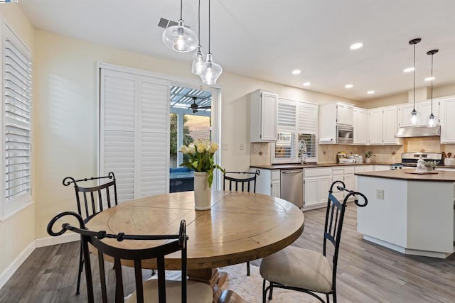 dining space featuring hardwood / wood-style floors and sink