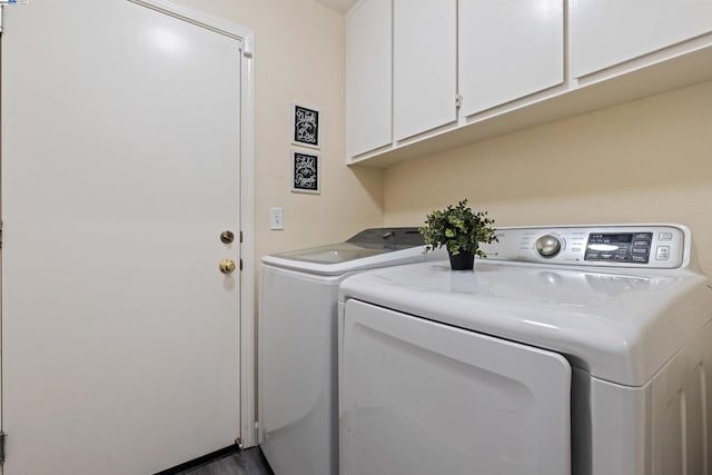 washroom featuring washing machine and dryer and cabinets