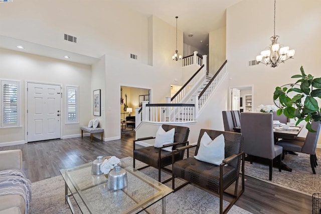 living room featuring a high ceiling, dark hardwood / wood-style flooring, and an inviting chandelier