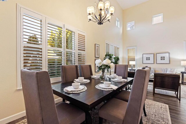 dining space with dark hardwood / wood-style floors and a chandelier