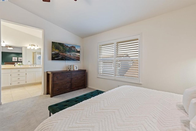 bedroom featuring ceiling fan, light colored carpet, lofted ceiling, ensuite bath, and sink