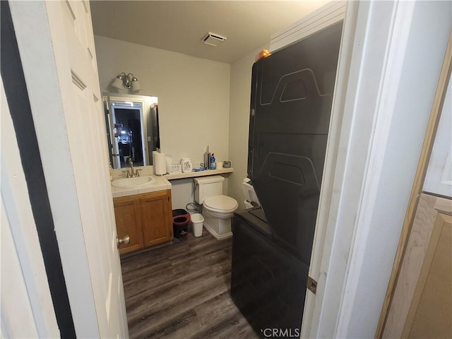 bathroom with wood-type flooring, toilet, and vanity