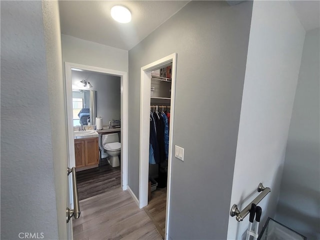 hall with light wood-type flooring and sink