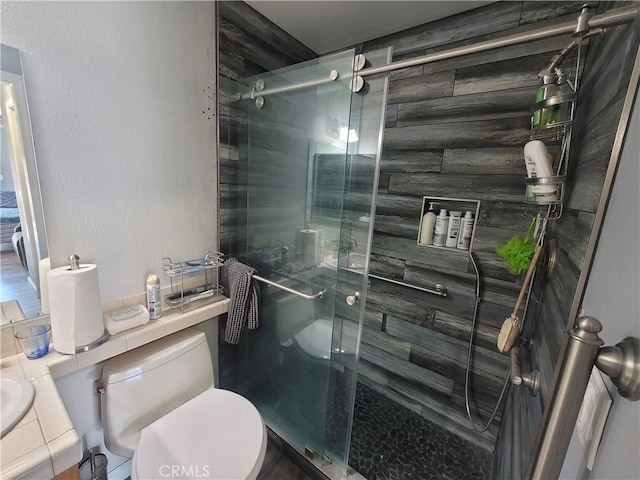 bathroom with a shower with shower door, toilet, and vanity