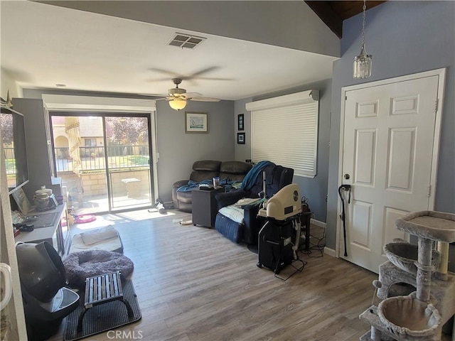 living room featuring ceiling fan, wood-type flooring, and vaulted ceiling