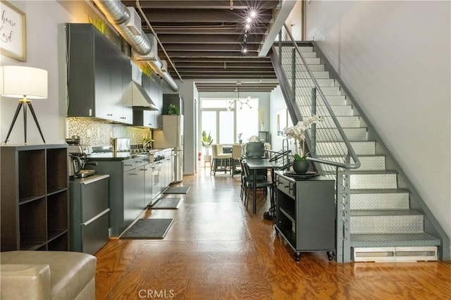 stairs featuring hardwood / wood-style flooring and sink