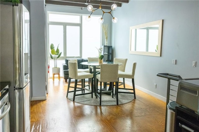 dining space with beam ceiling and hardwood / wood-style flooring